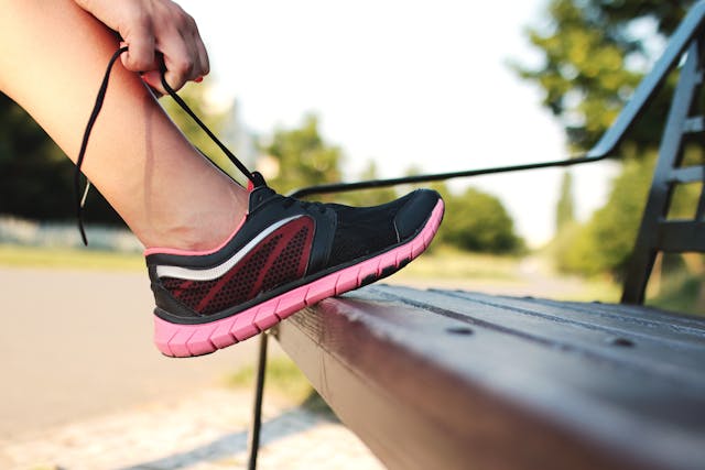 Person stepping on a bench to tie their shoe