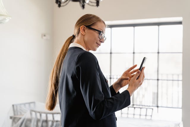 woman in a suit and glasses taking photos of a home